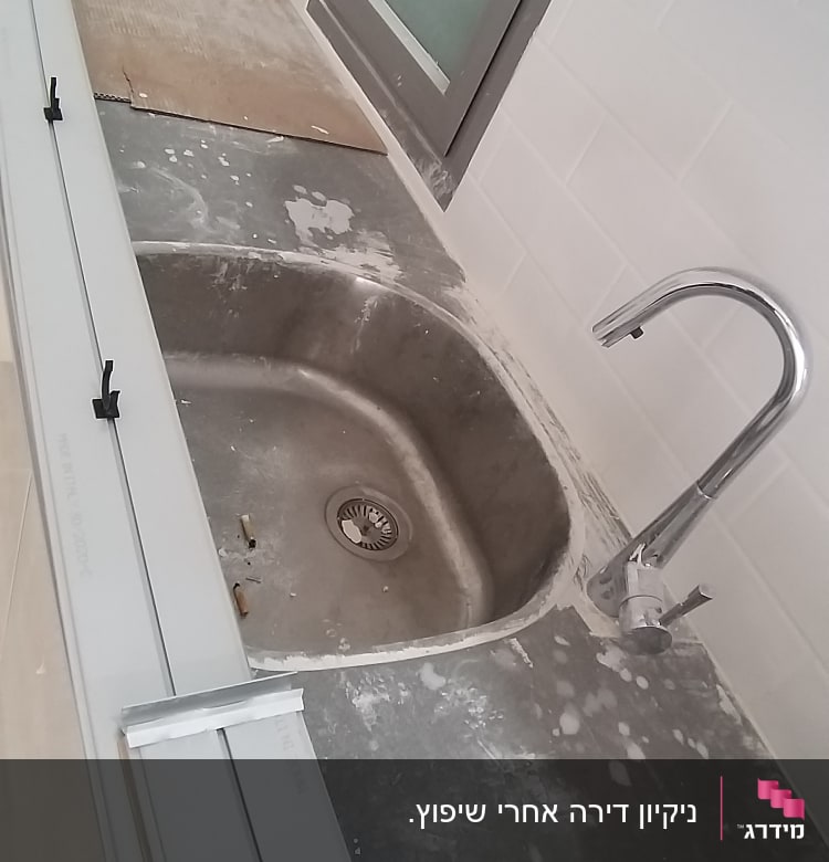 כיור מלוכלך עם כתמי אבק על השיש